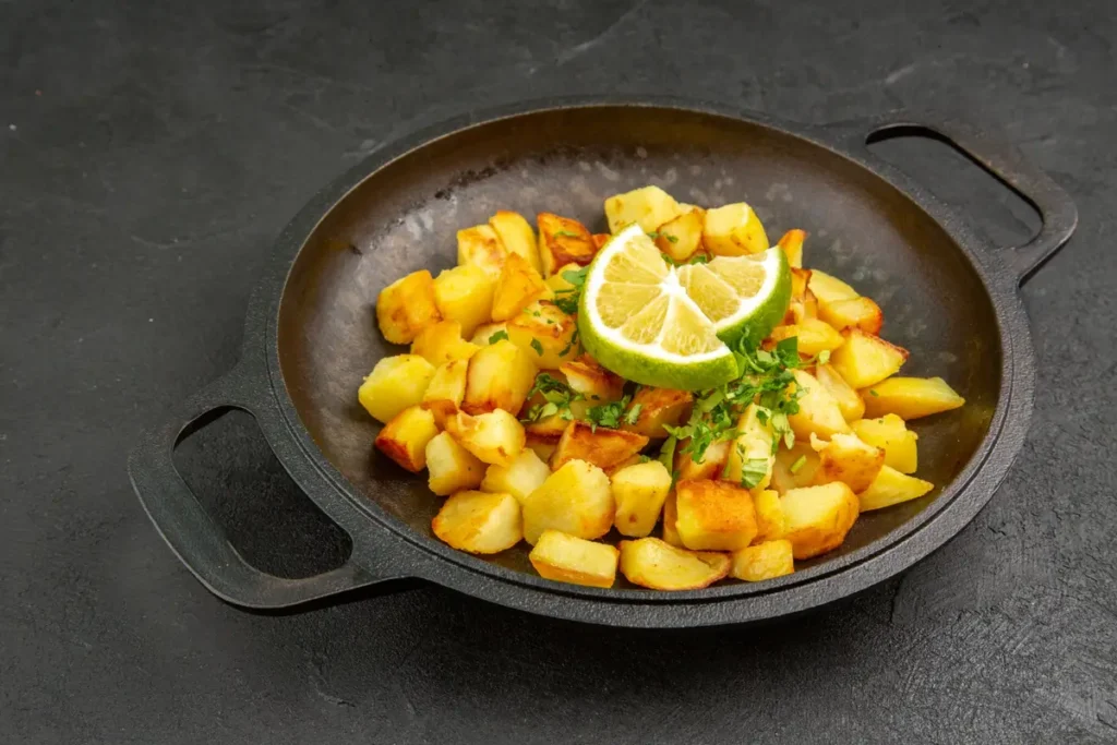 "Crispy Mexican breakfast potatoes in a skillet with bell peppers and onions."