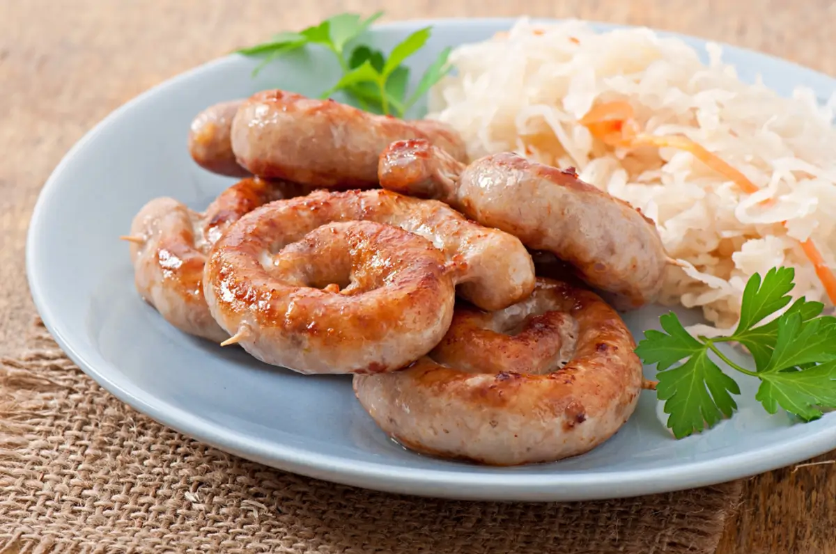 "A plate of freshly cooked breakfast sausage links with eggs and toast"