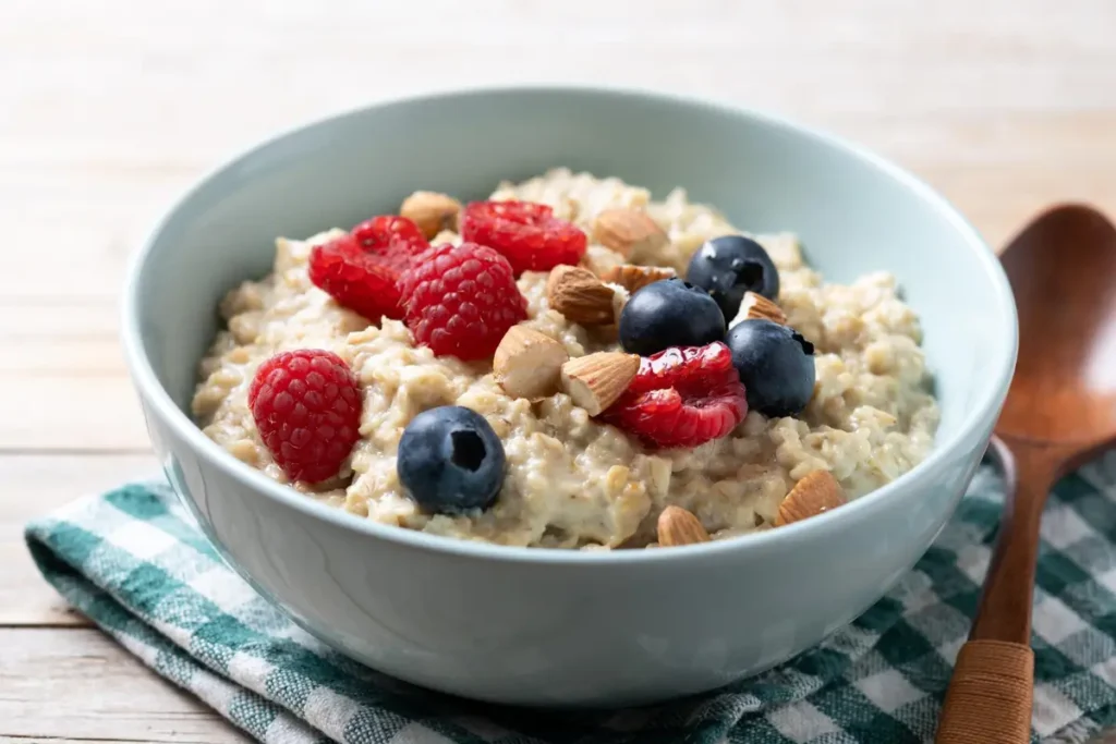 A bowl of creamy overnight oats topped with fresh berries, nuts, and honey.